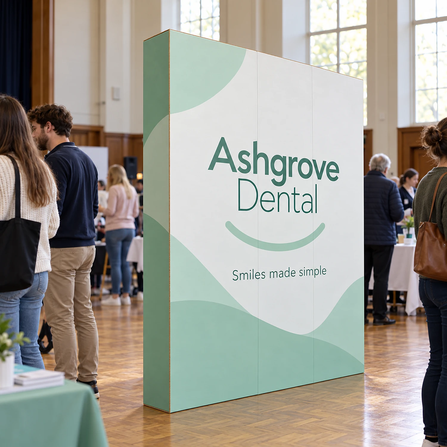 1.68m Cardboard Display Wall with an example design, in use at a community health fair in a town hall with a parquet floor