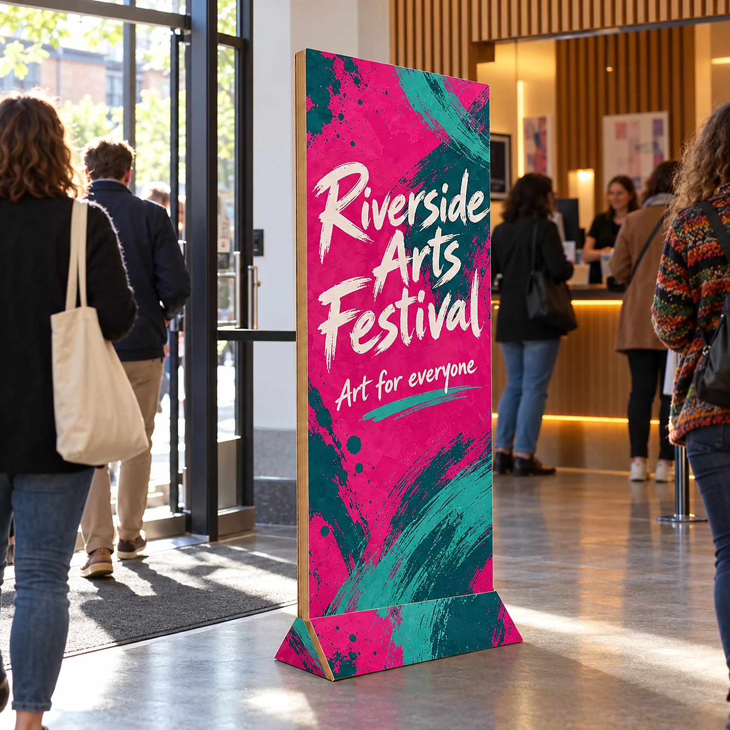 600mm Cardboard Banner Stand with an example design, in use at the entrance foyer of a theatre or arts centre with a box office in the background