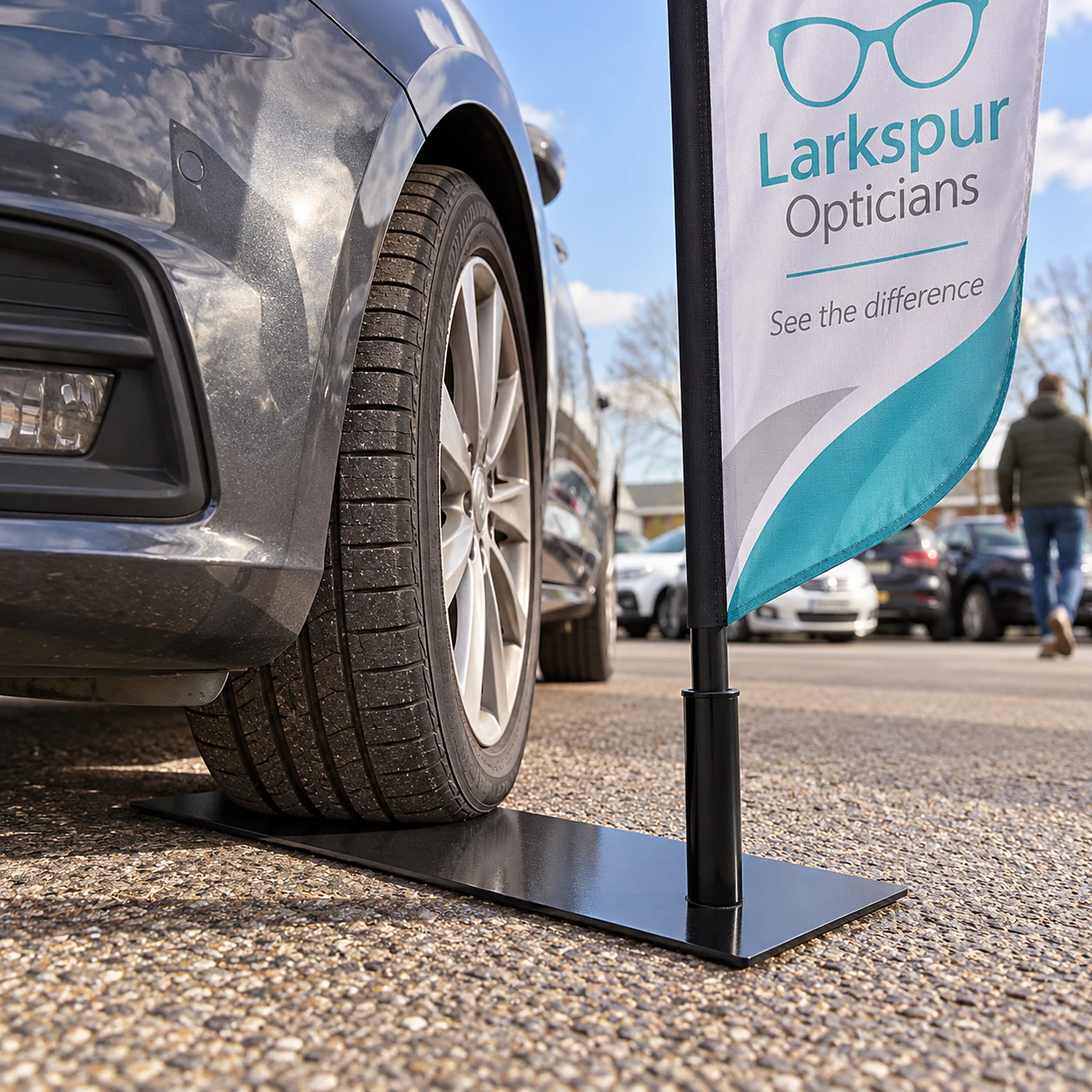 Car wheel base holding a flag on a garage forecourt