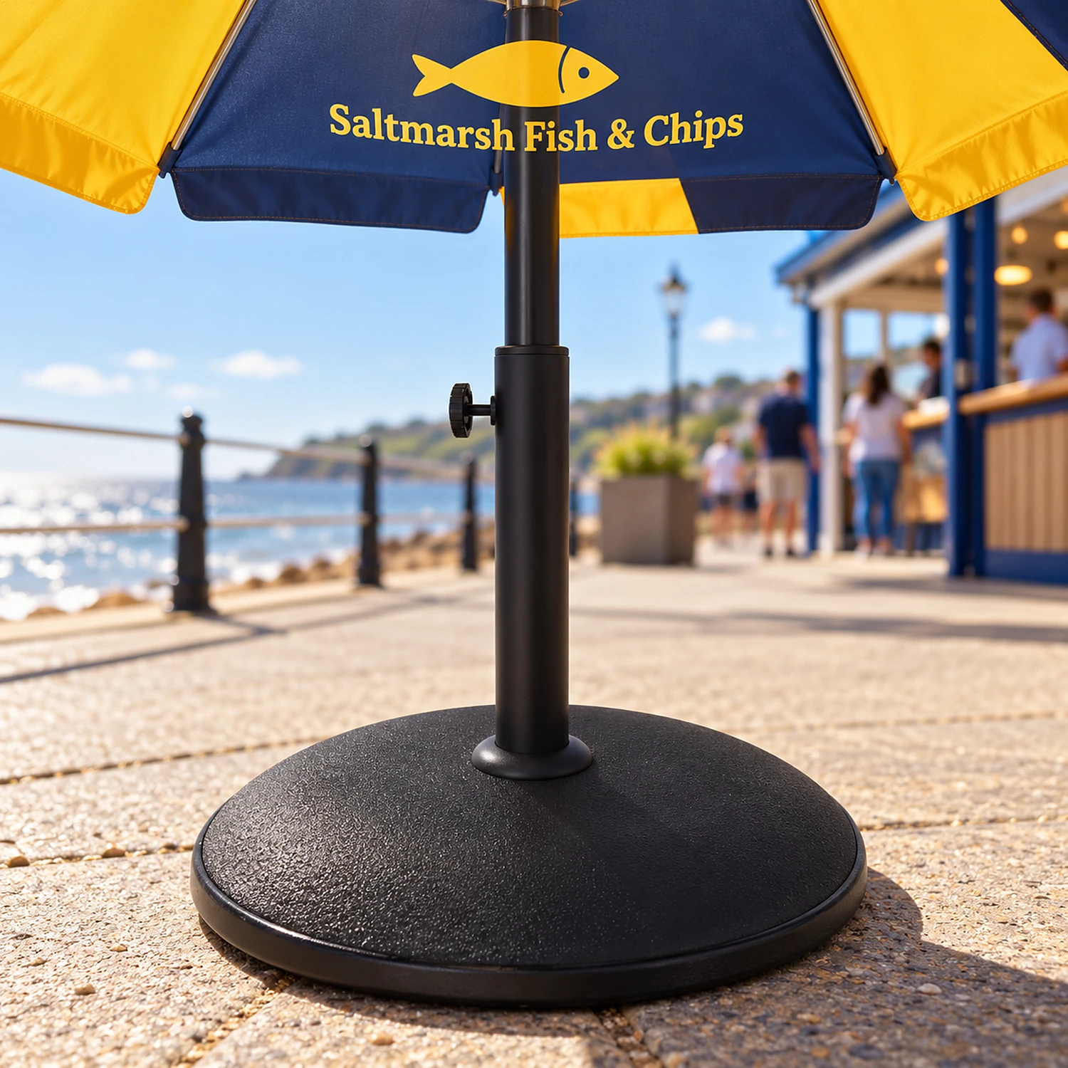 Parasol base holding a parasol on a seaside promenade