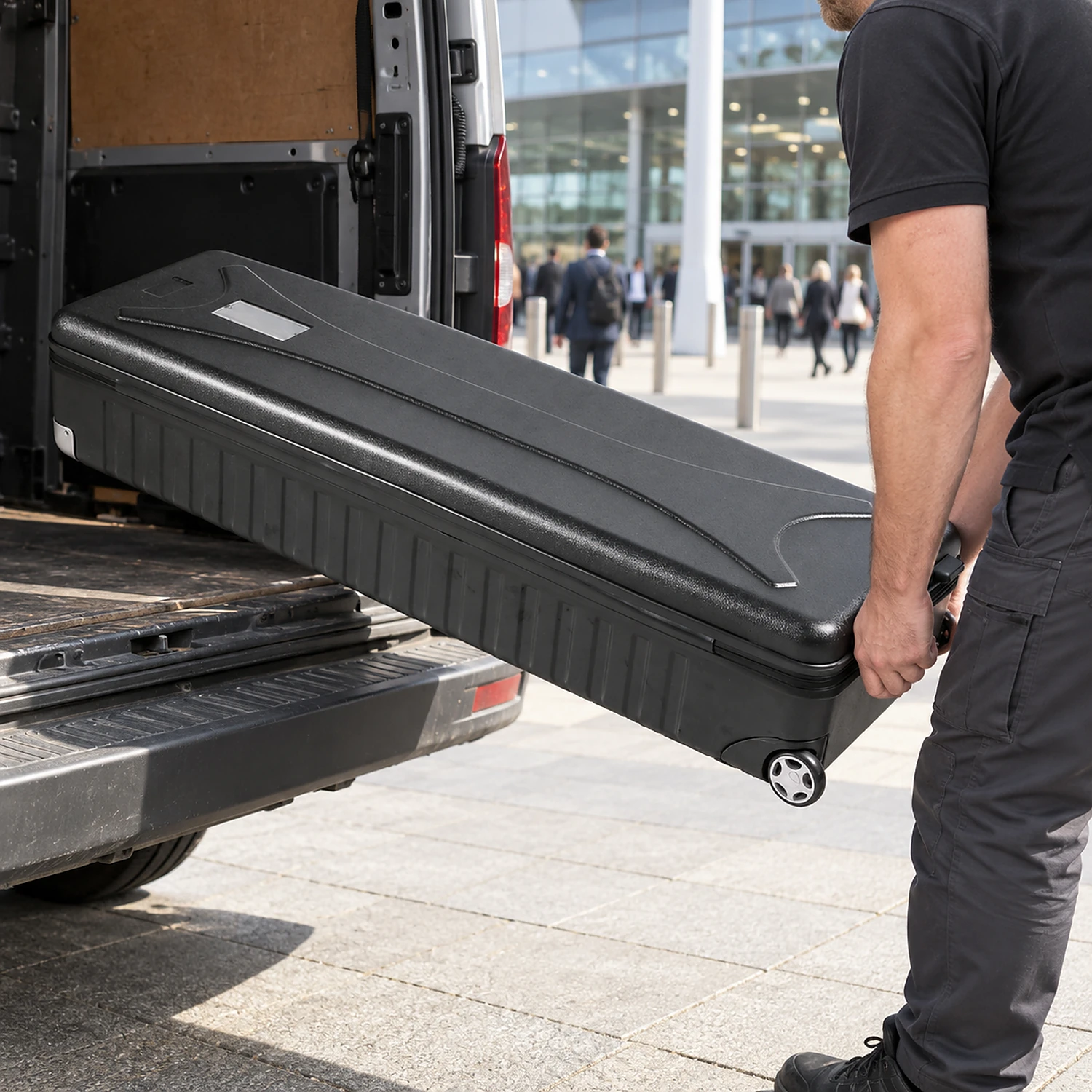 Wheeled hard case being loaded into a van