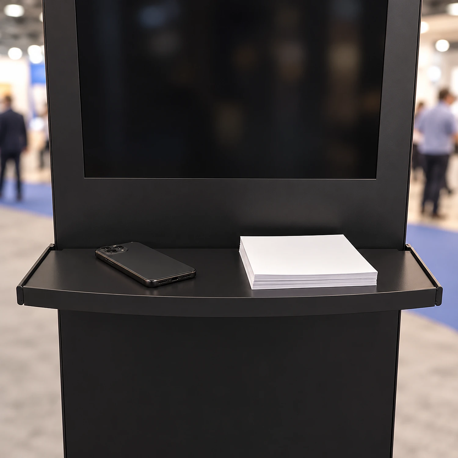 Black shelf with charger fitted below a kiosk screen at an exhibition