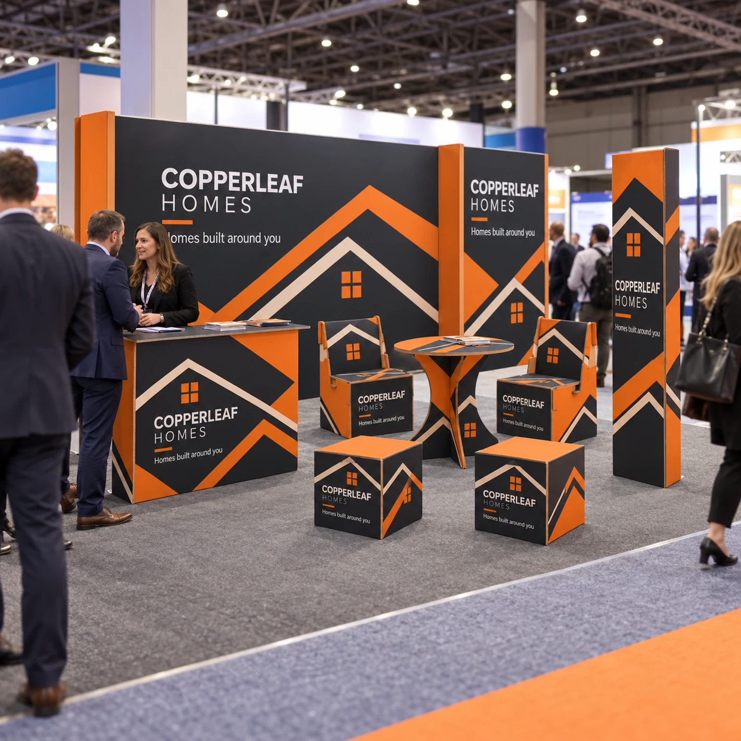 6m x 3m Cardboard Lounge Stand Kit - 5.85m Back Wall, Counter, Round Table, Seating & Triangle Totem in use at a trade show, shown with an example design