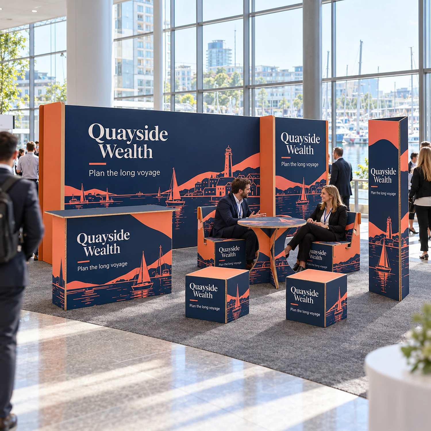 6m x 3m Cardboard Lounge Stand Kit with an example design, in use at a modern conference centre exhibition foyer with floor-to-ceiling glass and daylight