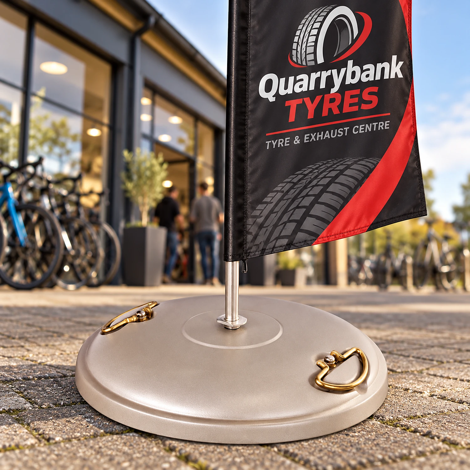Concrete flag base holding a feather flag on a shop forecourt