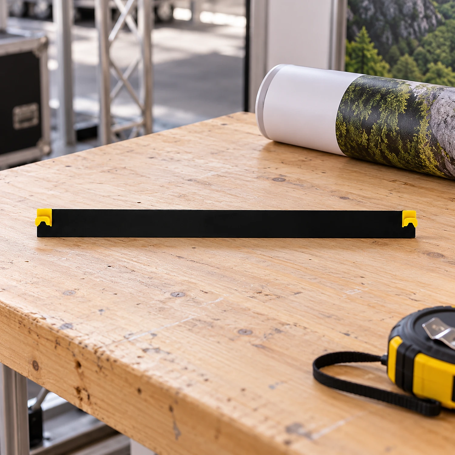 Curved end hanger on a workbench beside a rolled graphic