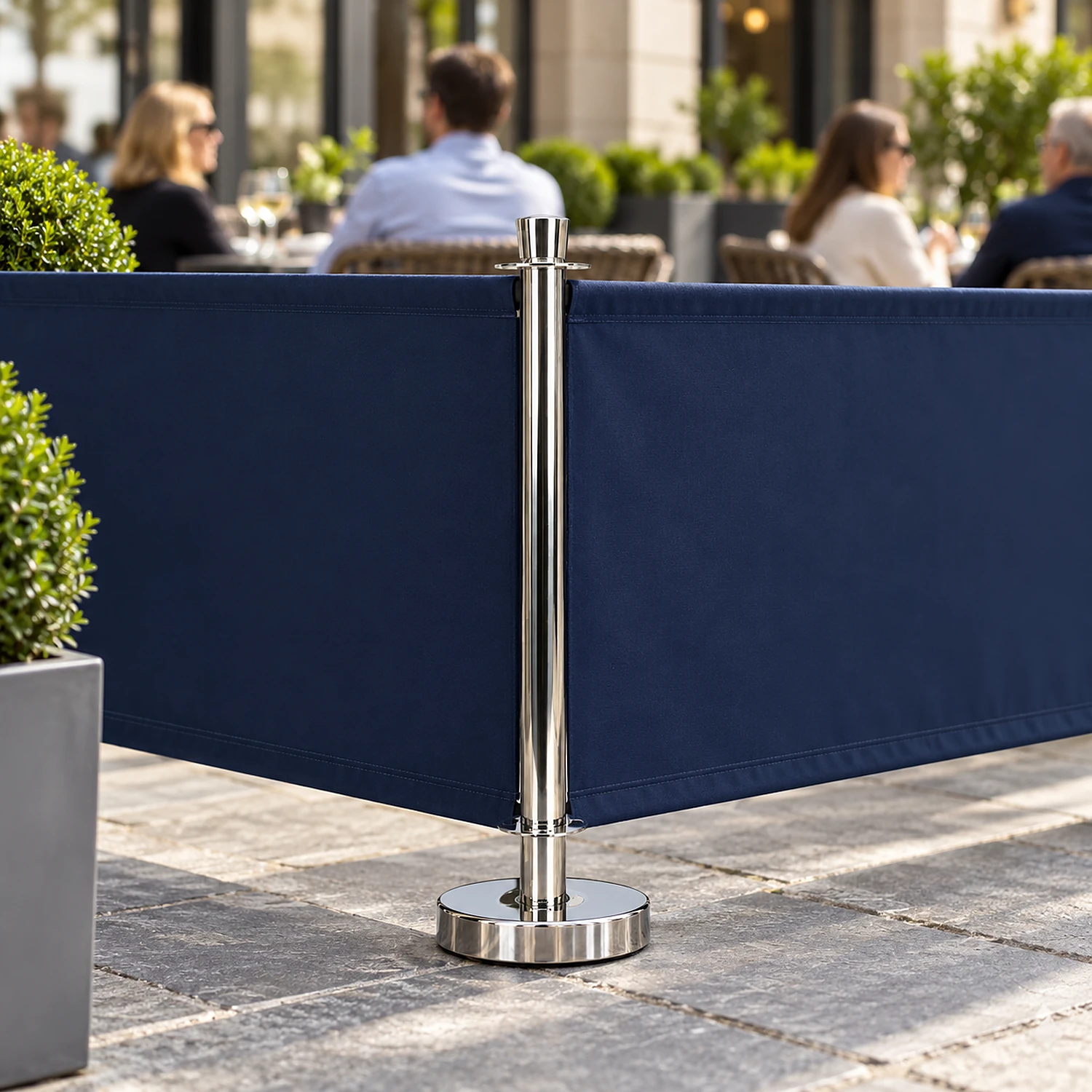 Chrome cafe barrier post at the corner of a barrier run on a hotel terrace