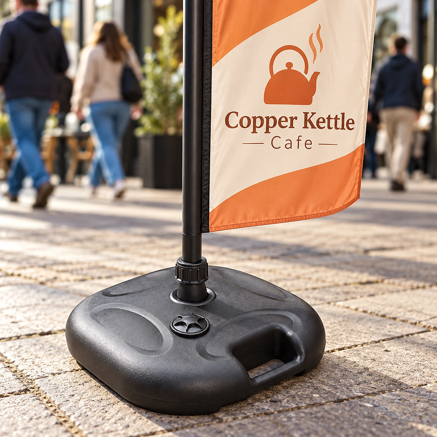 Basic parasol flag base holding a flag on a paved forecourt
