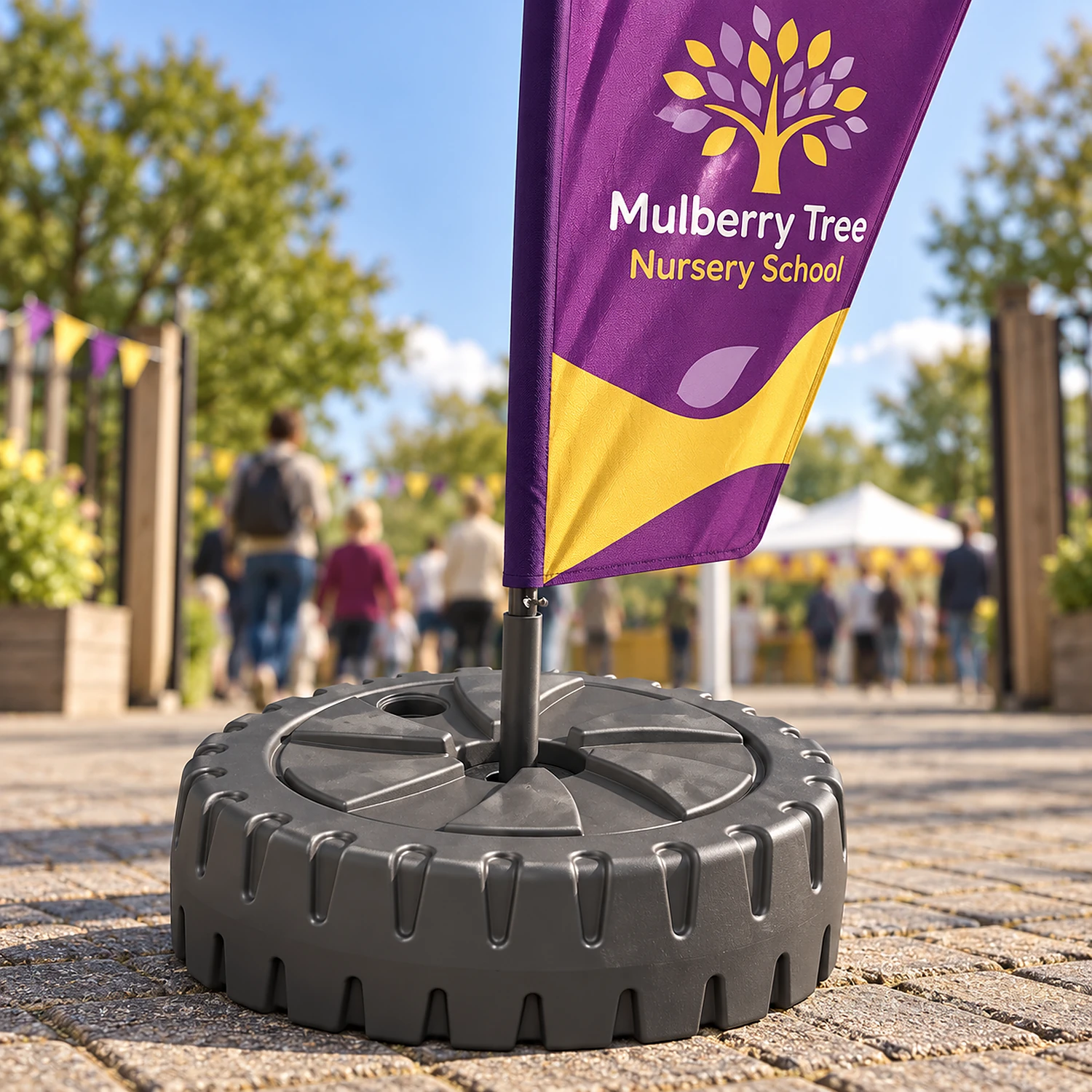 Large parasol flag base holding a tall feather flag at an event entrance