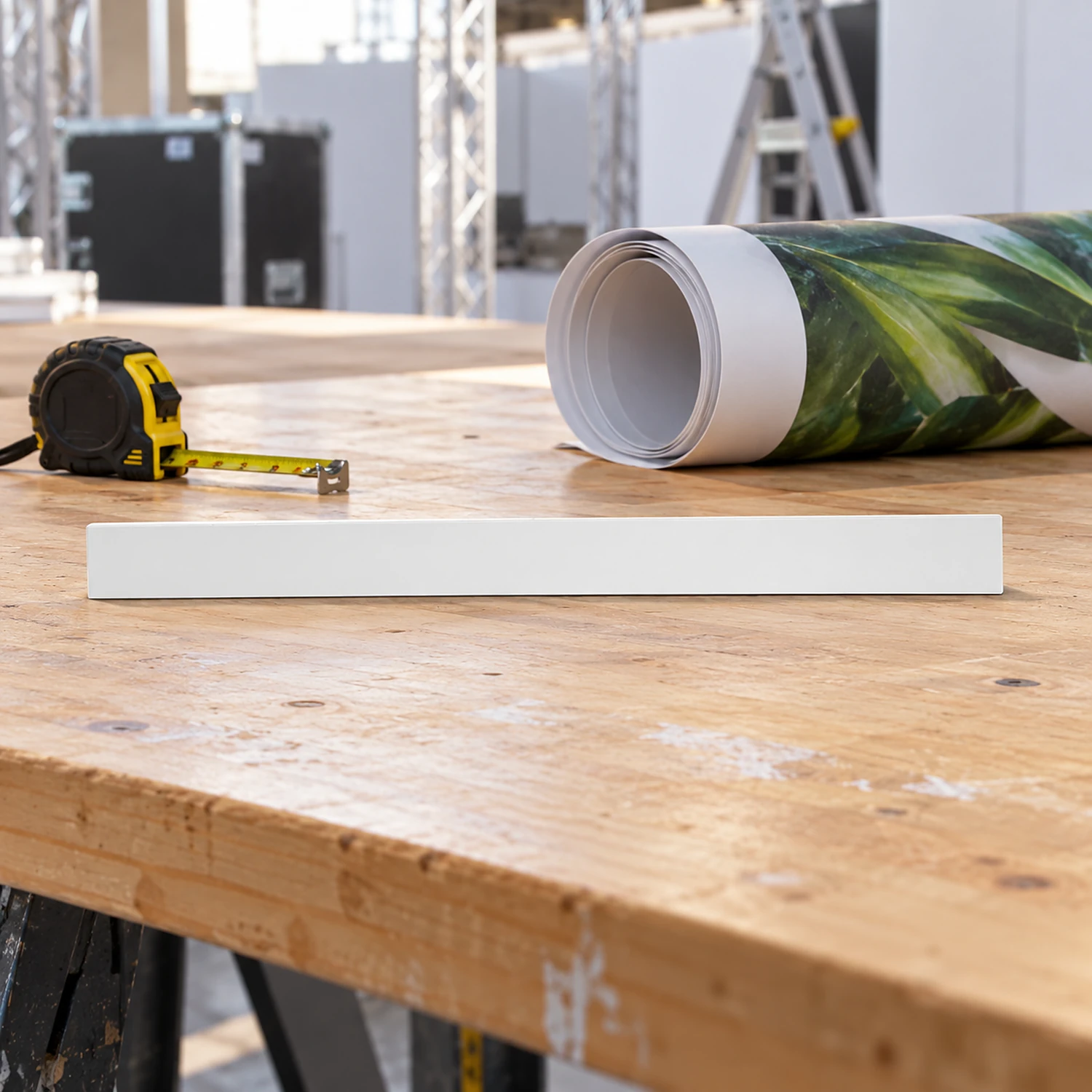 Front curved kicker on a workbench beside a rolled graphic